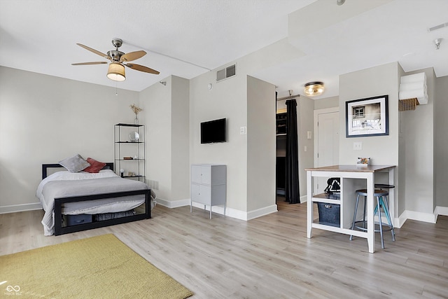 bedroom featuring wood finished floors, visible vents, and baseboards