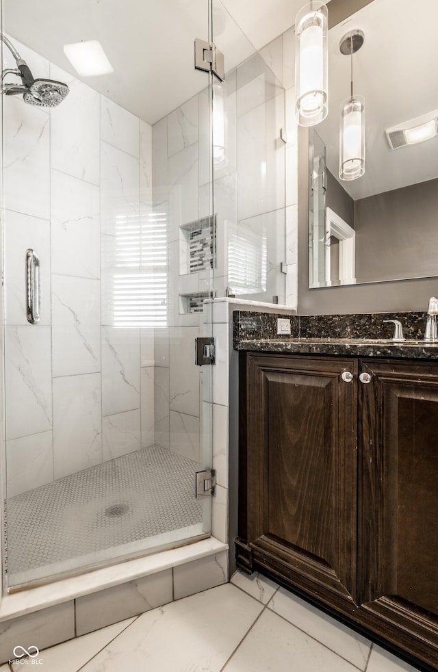 bathroom featuring vanity, visible vents, and a marble finish shower