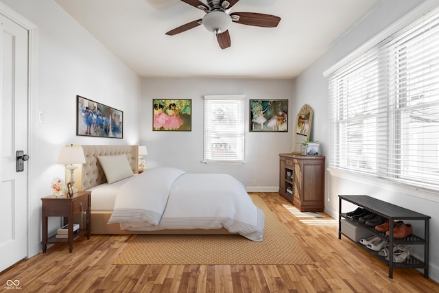 bedroom featuring light wood finished floors, baseboards, and ceiling fan