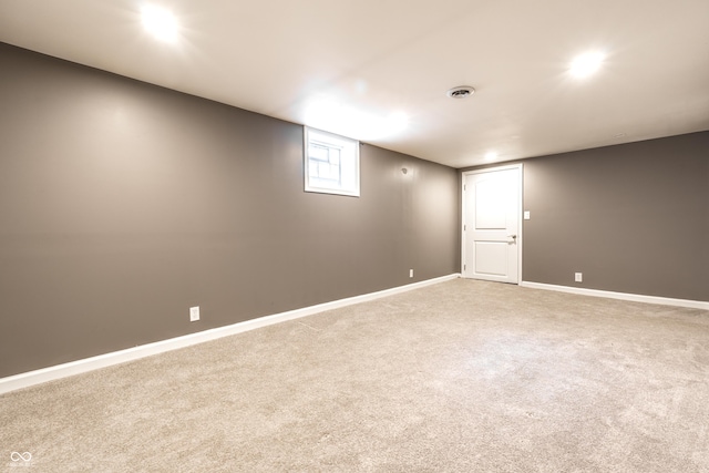 carpeted spare room featuring visible vents and baseboards