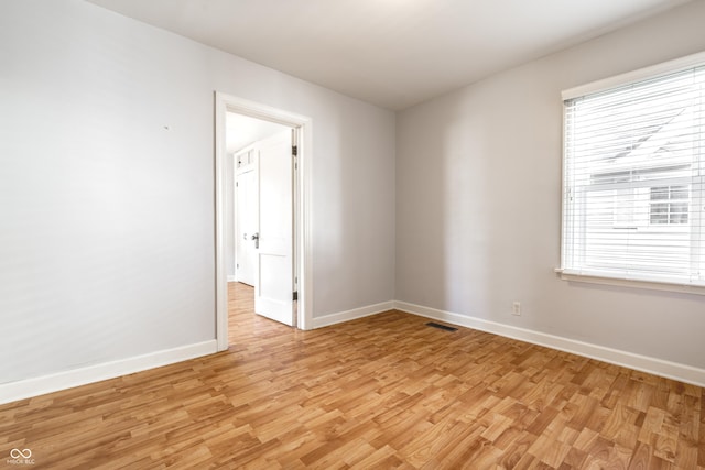 spare room featuring visible vents, light wood-type flooring, and baseboards