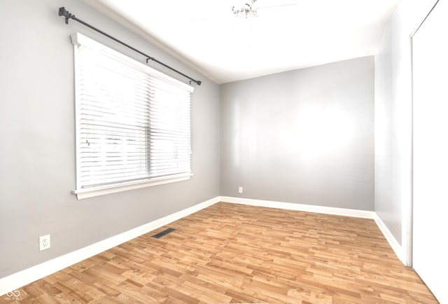 unfurnished room featuring visible vents, baseboards, light wood-style floors, and a ceiling fan