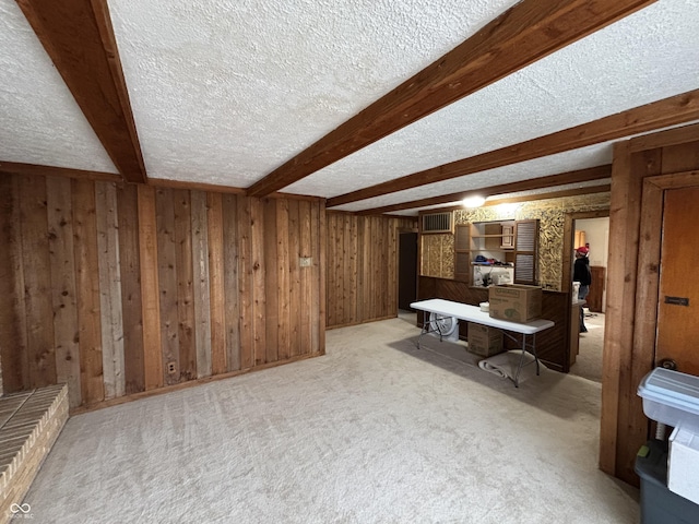 interior space featuring wooden walls, a textured ceiling, visible vents, and carpet floors