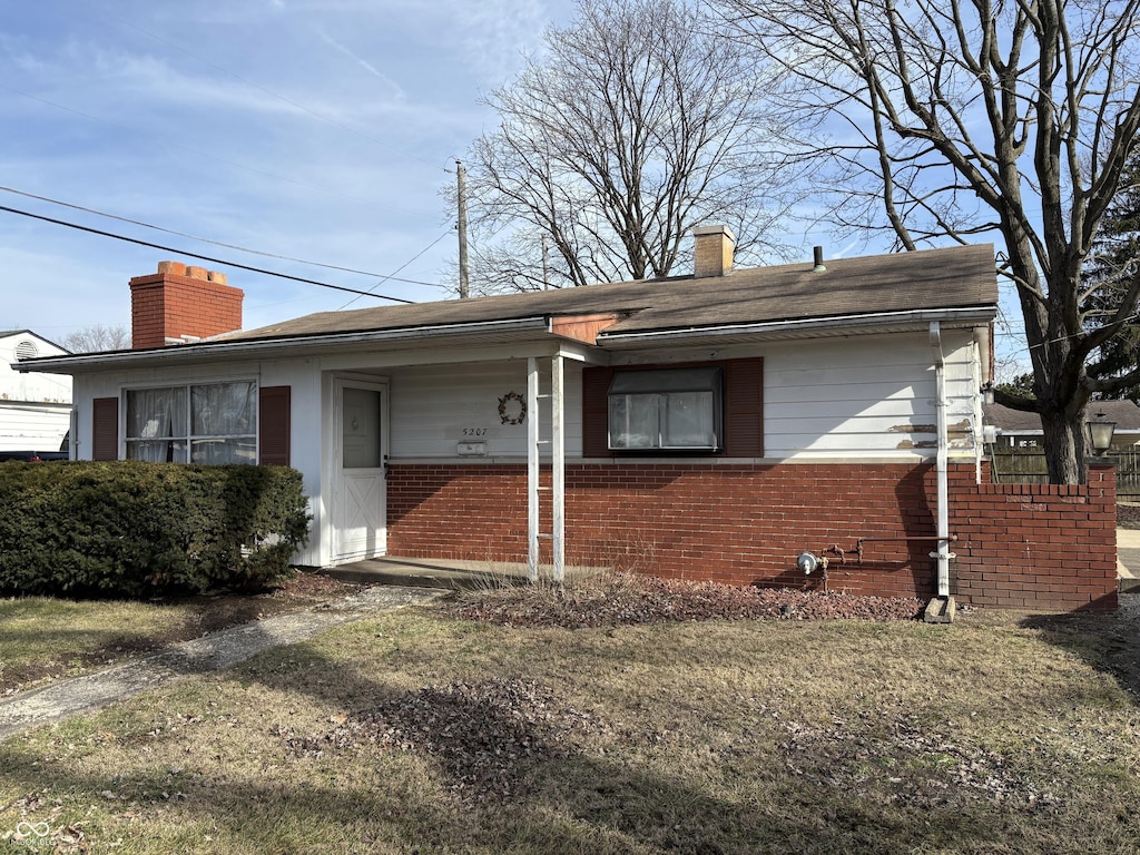 view of front of property with brick siding and a chimney