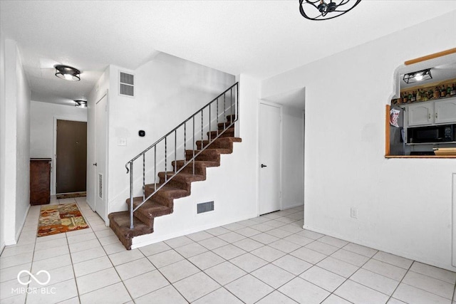 staircase with visible vents and tile patterned flooring