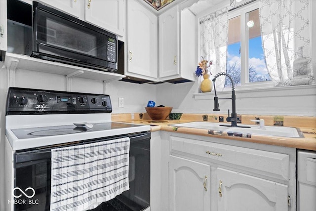 kitchen featuring a sink, black microwave, electric range oven, and white cabinetry