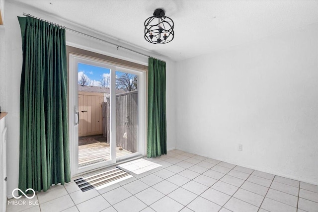 unfurnished room with light tile patterned floors and a textured ceiling