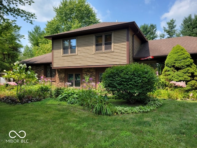 tri-level home with a front lawn, brick siding, and a shingled roof