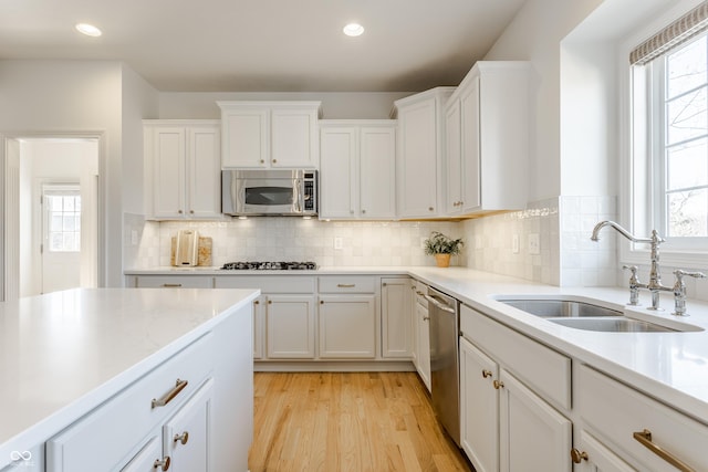 kitchen featuring white cabinets, plenty of natural light, appliances with stainless steel finishes, and a sink