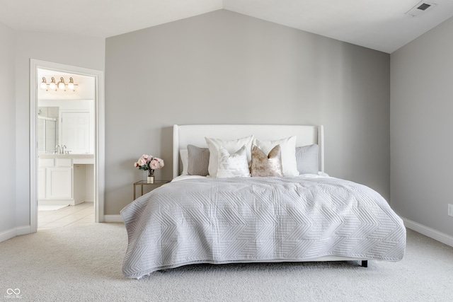 carpeted bedroom featuring ensuite bath, visible vents, baseboards, and lofted ceiling