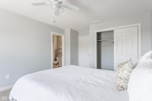 bedroom featuring ceiling fan, baseboards, carpet, ensuite bathroom, and a closet