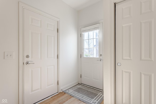 entryway with light wood-style flooring and baseboards