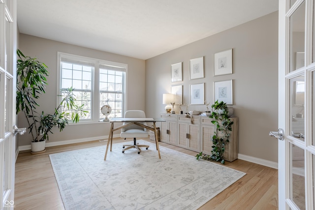 home office featuring light wood-style flooring, french doors, and baseboards