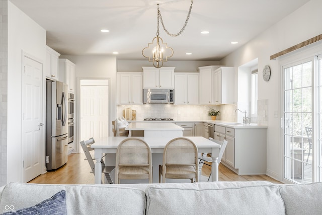 kitchen featuring a sink, decorative backsplash, a kitchen island, and stainless steel appliances