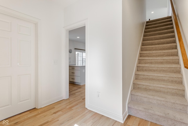 staircase with baseboards and wood finished floors