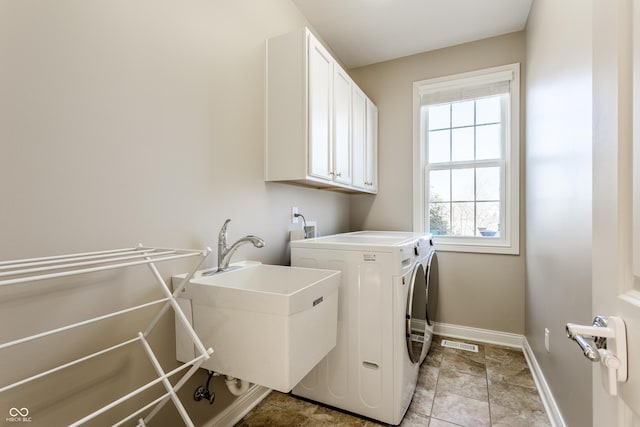 washroom with visible vents, independent washer and dryer, a sink, cabinet space, and baseboards