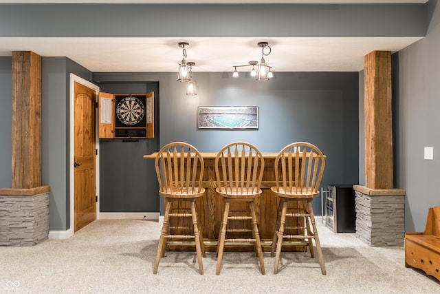 dining space with ornate columns, a dry bar, baseboards, and carpet