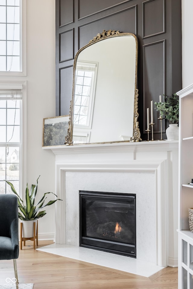 interior details with a fireplace with flush hearth and wood finished floors