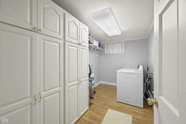 washroom featuring baseboards, light wood-style flooring, cabinet space, crown molding, and washer and clothes dryer