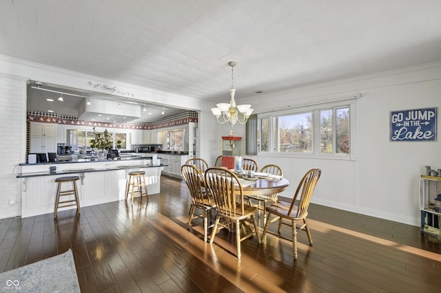 dining room featuring a chandelier, dark wood-style floors, crown molding, and baseboards