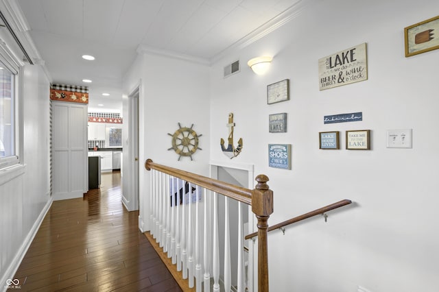 corridor with visible vents, crown molding, dark wood-type flooring, an upstairs landing, and recessed lighting