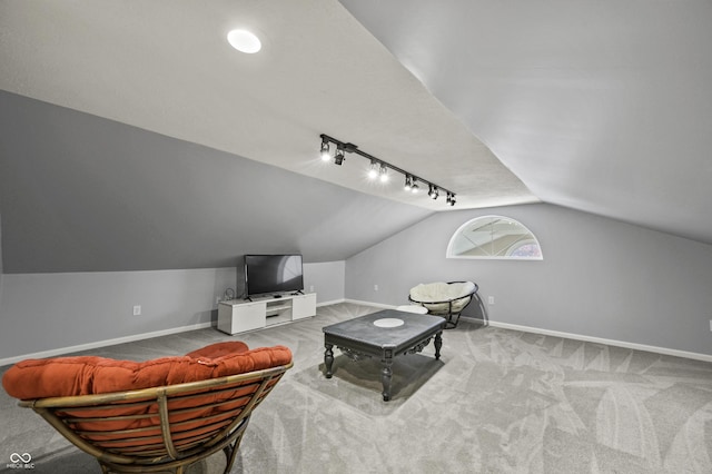 living room featuring rail lighting, baseboards, carpet, and vaulted ceiling