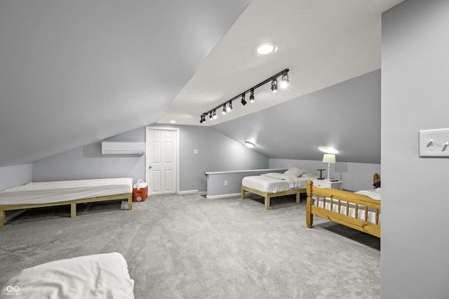 carpeted bedroom with a wall unit AC, rail lighting, baseboards, and lofted ceiling