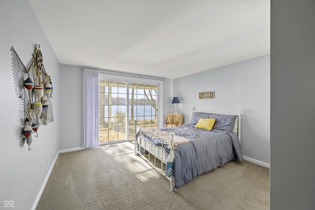 bedroom with a water view, baseboards, and carpet floors