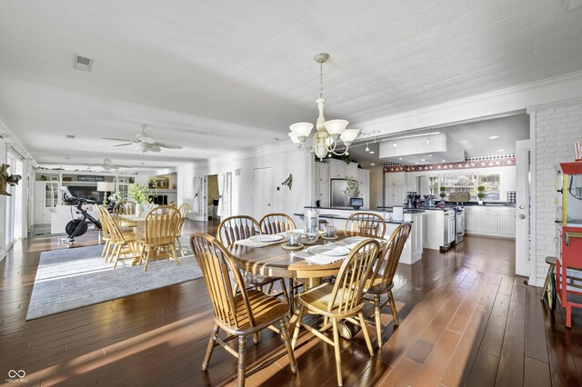 dining space with visible vents, ornamental molding, dark wood-style flooring, and ceiling fan with notable chandelier