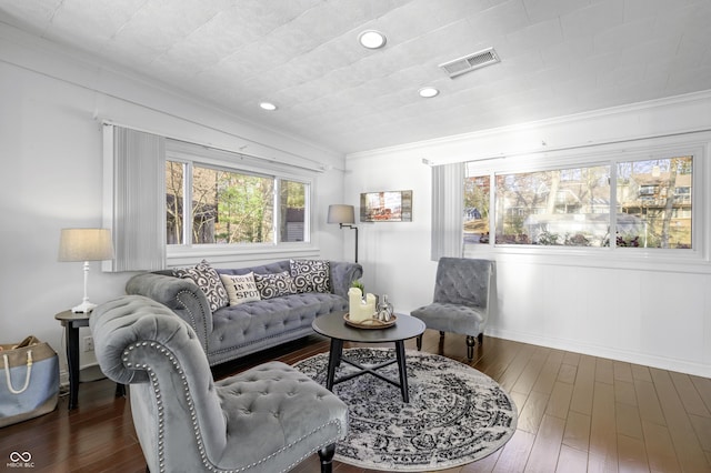 living room featuring visible vents, baseboards, ornamental molding, recessed lighting, and wood finished floors