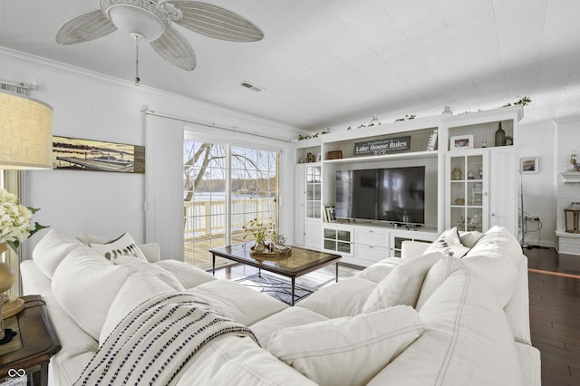 living area with hardwood / wood-style floors, ceiling fan, visible vents, and ornamental molding