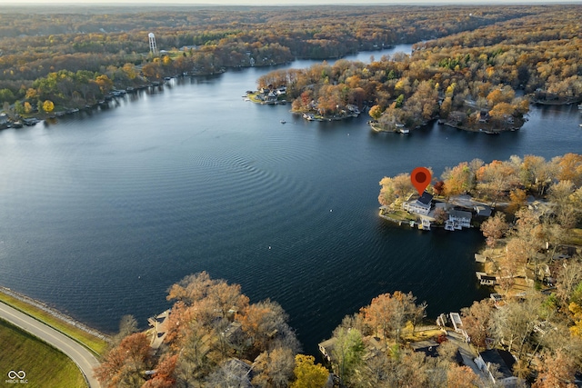 aerial view featuring a forest view and a water view