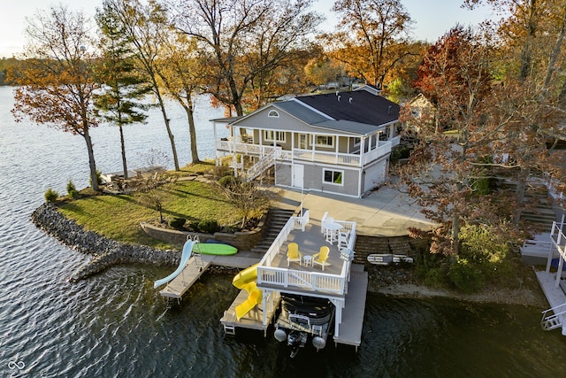 exterior space with a deck with water view, stairs, and a patio area