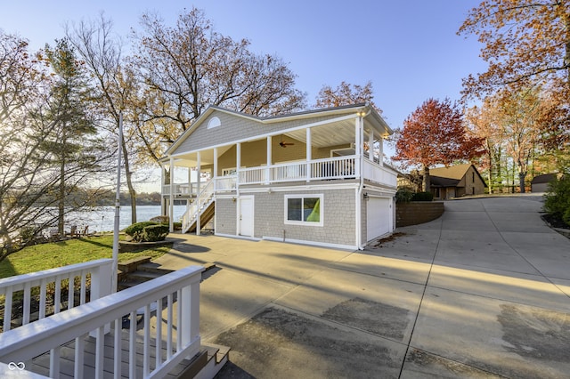 view of front facade featuring stairway, covered porch, a garage, driveway, and a ceiling fan