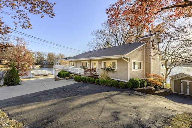 view of front of home featuring an outbuilding, a chimney, and a storage shed