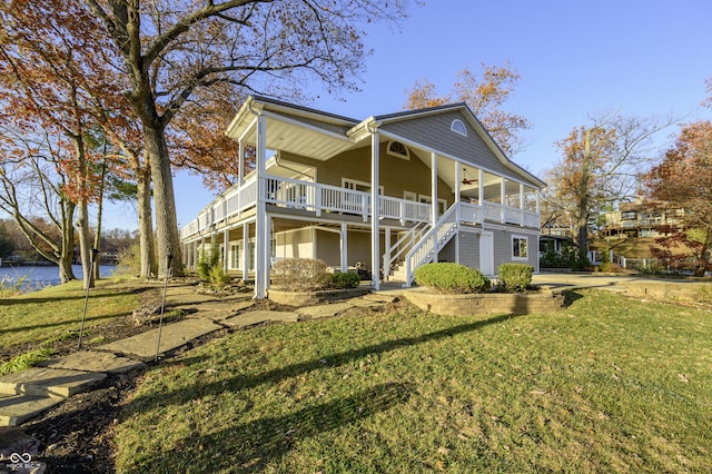 rear view of property with covered porch, a lawn, stairs, and a ceiling fan