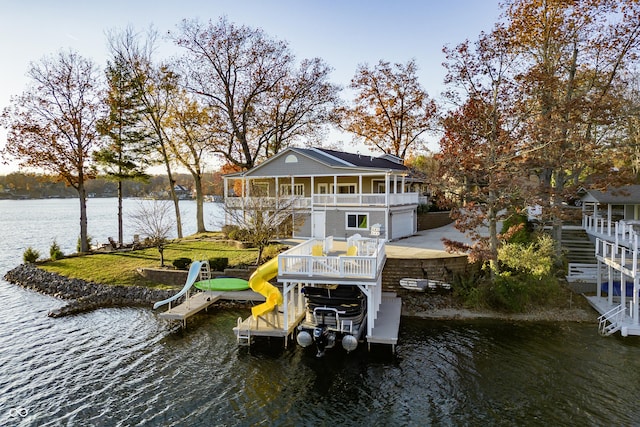 view of dock with stairway, a deck with water view, and boat lift