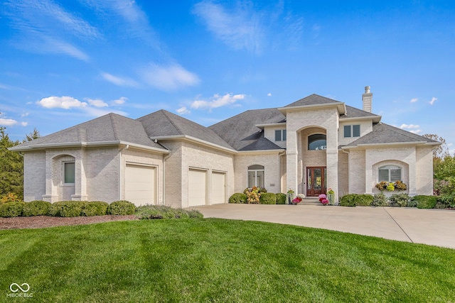 french country home featuring brick siding, a shingled roof, a front lawn, a garage, and driveway