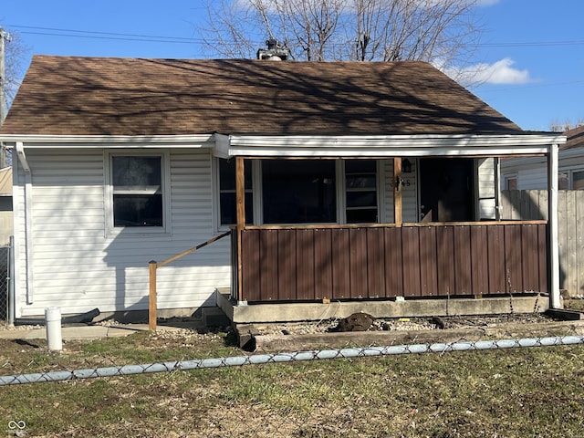 exterior space featuring a porch and a shingled roof