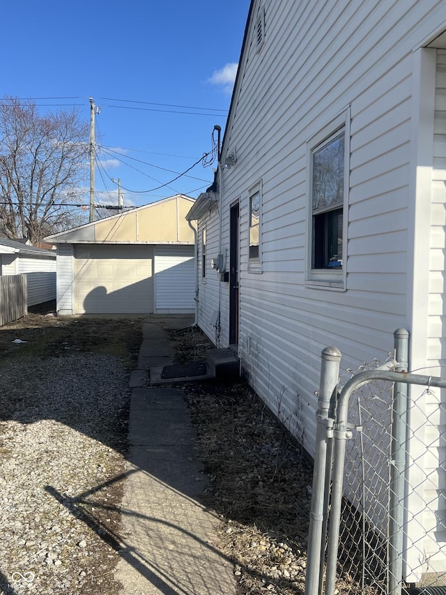 view of home's exterior with an outbuilding and fence