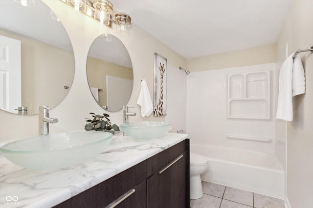 bathroom featuring tile patterned floors, toilet, bathtub / shower combination, and a sink