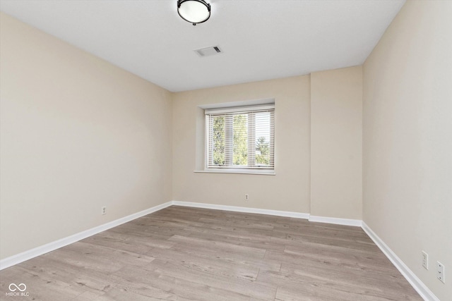 unfurnished room with baseboards, visible vents, and light wood finished floors