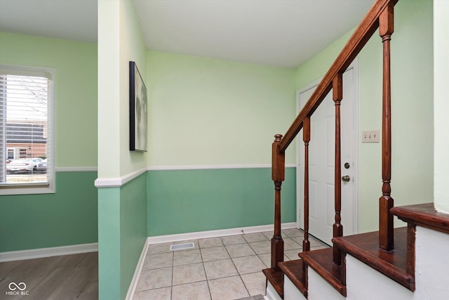 foyer entrance featuring tile patterned floors, stairway, baseboards, and visible vents