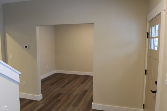 foyer entrance with dark wood-style floors and baseboards