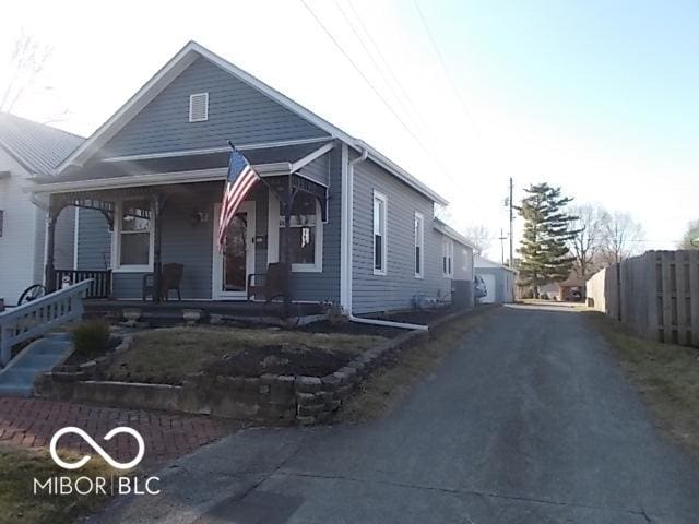 view of front of house featuring covered porch and fence