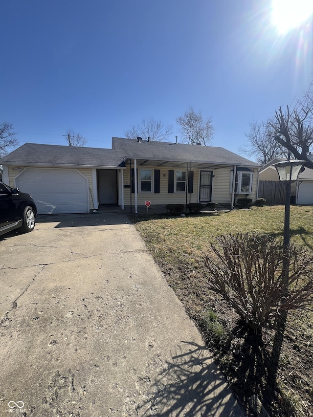 single story home with a front lawn, an attached garage, fence, and driveway