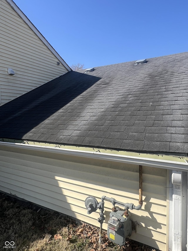 details with gas meter and a shingled roof