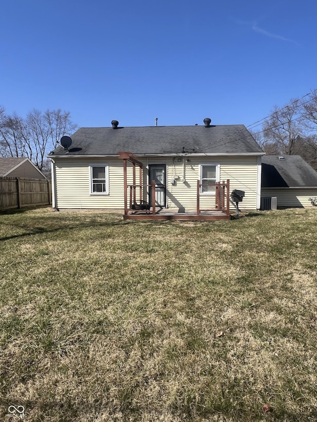 back of house with a lawn and fence