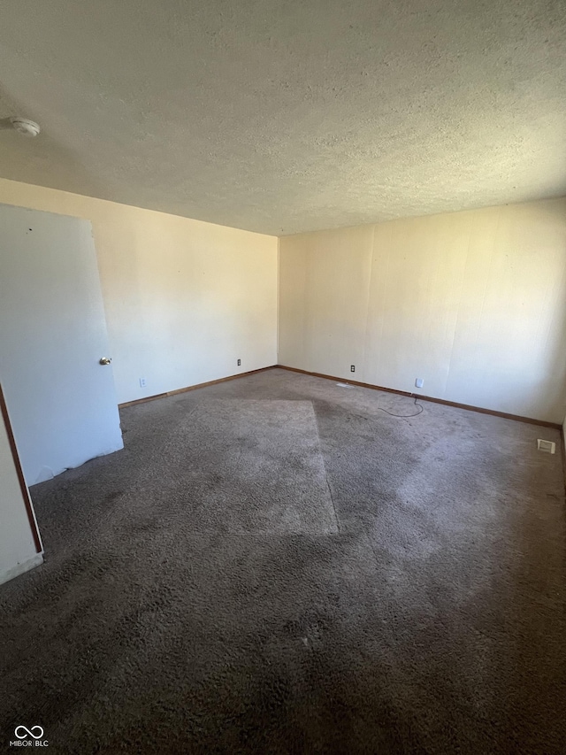 carpeted empty room with a textured ceiling