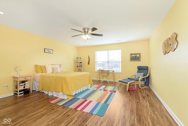 bedroom featuring ceiling fan, baseboards, and wood finished floors